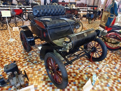 An early automobile from the 1900s to 1910s on a public road, the machine whose danger pointed outward at strangers and made liability insurance a mass product