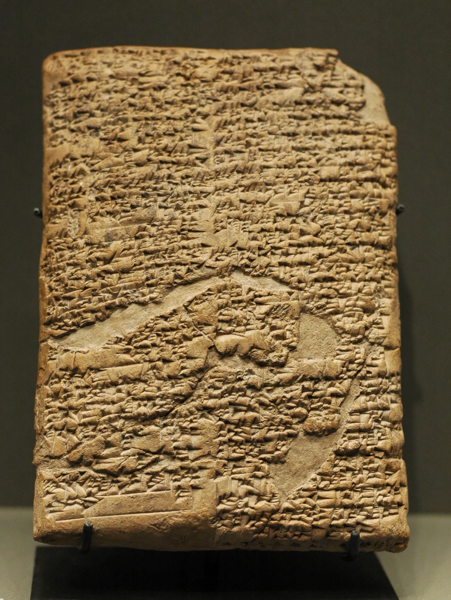 Clay cuneiform tablet inscribed with the prologue of the Code of Hammurabi, displayed upright on a museum stand.
